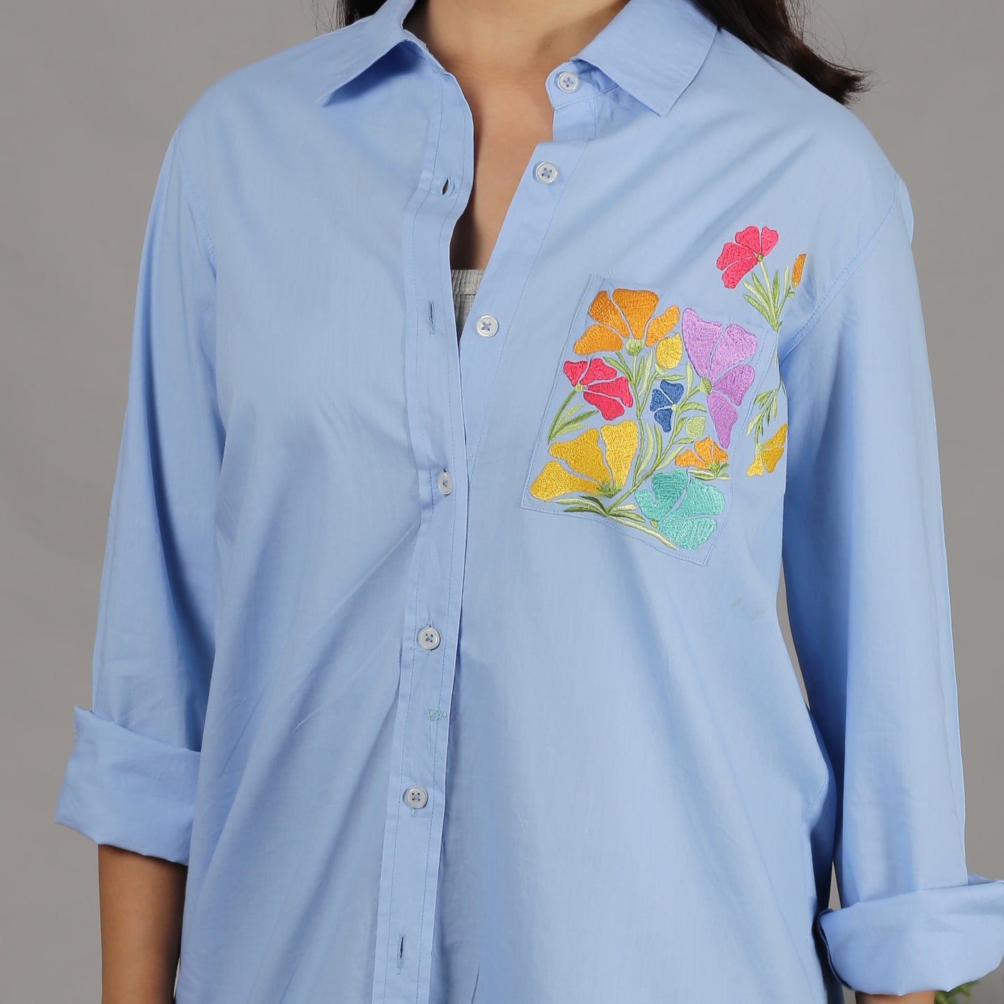 Blue shirt with floral embroidery on the pocket